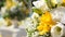 Yellow and white flowers in decorative vases to decorate yard for wedding ceremony