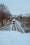 Yellow and white locomotive chugging down snow-covered railroad tracks, the wintery landscape