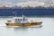 Yellow and white small pilot boat enters the port