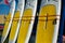 Yellow and white surfboards stand on the beach.