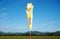 Yellow and white windsock placed in a large field during daylight