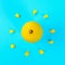 Yellow whole lemon in the form of the sun and rays from the petals of a yellow flower on a pastel blue background.