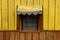 Yellow window of a wooden cottage