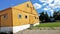 Yellow Wooden Barn, Blue Cloudy Sky