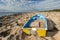 Yellow wooden boat stranded on stony shore with dramatic cloudy sky after storm