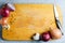 Yellow wooden cutting Board. Onions, kitchen knife and spices. Copy space