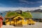 Yellow wooden house with grass on top