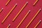 Yellow wooden pencil on red background