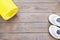 Yellow yoga mat and sport shoes on dark brown wooden background