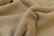 A yellowish brown fluffy short fur fleece fabric look cozy was lying on the floor