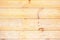 Yellowish wood planks with knotholes as background photo.