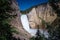 Yellowstone Falls waterfall as seen from the Uncle Tom`s Trail with a small rainbow on a sunny day