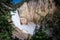 Yellowstone Falls waterfall as seen from the Uncle Tom`s Trail with a small rainbow on a sunny day