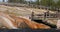 Yellowstone hot geyser waterfall into river tourists bridge 4K