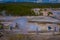 YELLOWSTONE, MONTANA, USA JUNE 02, 2018: People walking in boardwalk among pools and geysers. The barren snow-colored