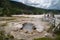 Yellowstone National Park, Wyoming - July 1, 2020: Family views a bubbling hot spring geyser in the Black Sand Basin area of the