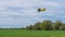 Yelow crop duster airplane flies over the farm field