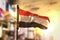 Yemen Flag Against City Blurred Background At Sunrise Backlight