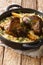 Yemeni dish of baked lamb shank served with aromatic rice close-up in a frying pan. vertical