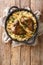 Yemeni dish of baked lamb shank served with aromatic rice close-up in a frying pan. vertical top view