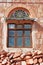 A yemeni old man behind a window in a red and decorated old house, Kawkaban, Republi