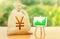 Yen Yuan money bag and easel with green positive growth graph. Recovery and growth of economy, good investment attractiveness.