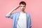 Yes sir! Portrait of diligent young brown-haired man looking serious at camera and saluting. isolated on pink background