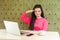 Yes sir! Portrait of faithful young girl freelancer with black dreadlocks hairstyle in pink blouse are sitting in cafe and holding