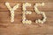 YES wrote with daisies on wooden background