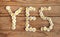 Yes wrote with daisies on wooden background