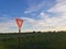 Yield sign next to a rural road during sunset