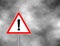 Yield Triangle Sign - Road traffic coordination symbol on clouds background. Road sign warning attention with an exclamation mark.