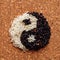 Yin-Yang symbol of black and white rice on the surface of the cork background