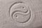 Yin yang symbol in sand