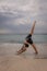 Yoga in Bali. Young woman practicing Eka Pada Adho Mukha Svanasana, One-Legged Down Dog. Straight back. Healthy lifestyle. Ocean