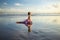 Yoga on the beach. Slim woman practicing Ardha Kapotasana, Half Pigeon Pose. Chest opener improving breathing. Healthy lifestyle.