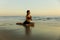 Yoga on the beach. Slim woman practicing Ardha Kapotasana, Half Pigeon Pose. Hands in namaste mudra. Chest opener improving