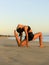Yoga on the beach. Variation of Low Lunge Pose, Anjaneyasana. Lunging back bending asana. Flexible spine and back. Healthy