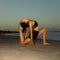 Yoga on the beach. Variation of Low Lunge Pose, Anjaneyasana. Lunging back bending asana. Flexible spine and back. Healthy