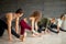 Yoga beginners exercising against grey wall, doing yoga or pilates posture.