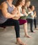 Yoga beginners exercising against grey wall, doing yoga or pilates posture.