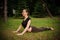 Yoga bhujangasana cobra pose by woman on green grass in the park