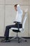 Yoga on chair in office - business man exercising