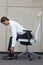 Yoga on chair in office - business man exercising