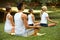 Yoga Class. Group of People Meditating At Summer Park