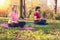 Yoga class. Joyful peaceful people sitting in the lotus pose while practicing yoga outdoors