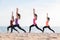 Yoga class at sea beach in evening ,Group of people doing Warrior poses with relax emotion