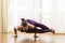 Yoga Concepts. Caucasian Woman Practicing Yoga Exercise Indoors At Bright Afternoon. Sitting in Ashtavakrasana Pose During