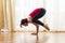 Yoga Concepts. Caucasian Woman Practicing Yoga Exercise Indoors At Bright Afternoon. Sitting in Bakasana Pose During Solitude