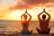 Yoga couple relaxing doing meditation on beach